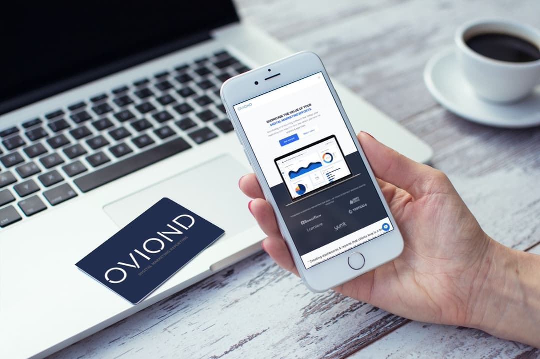 Person holding a phone with business card in front of them