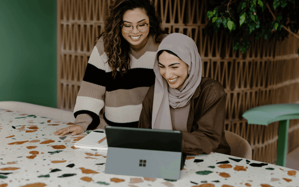 Two diverse professionals collaboratively reviewing a Keyword Research Report on a tablet in a modern, well-lit workspace.