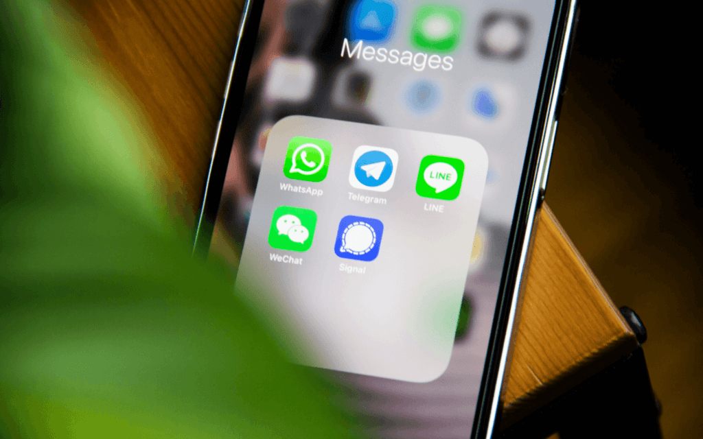 Smartphone screen with various messaging app icons, signifying the use of digital marketing innovations in communication technology.