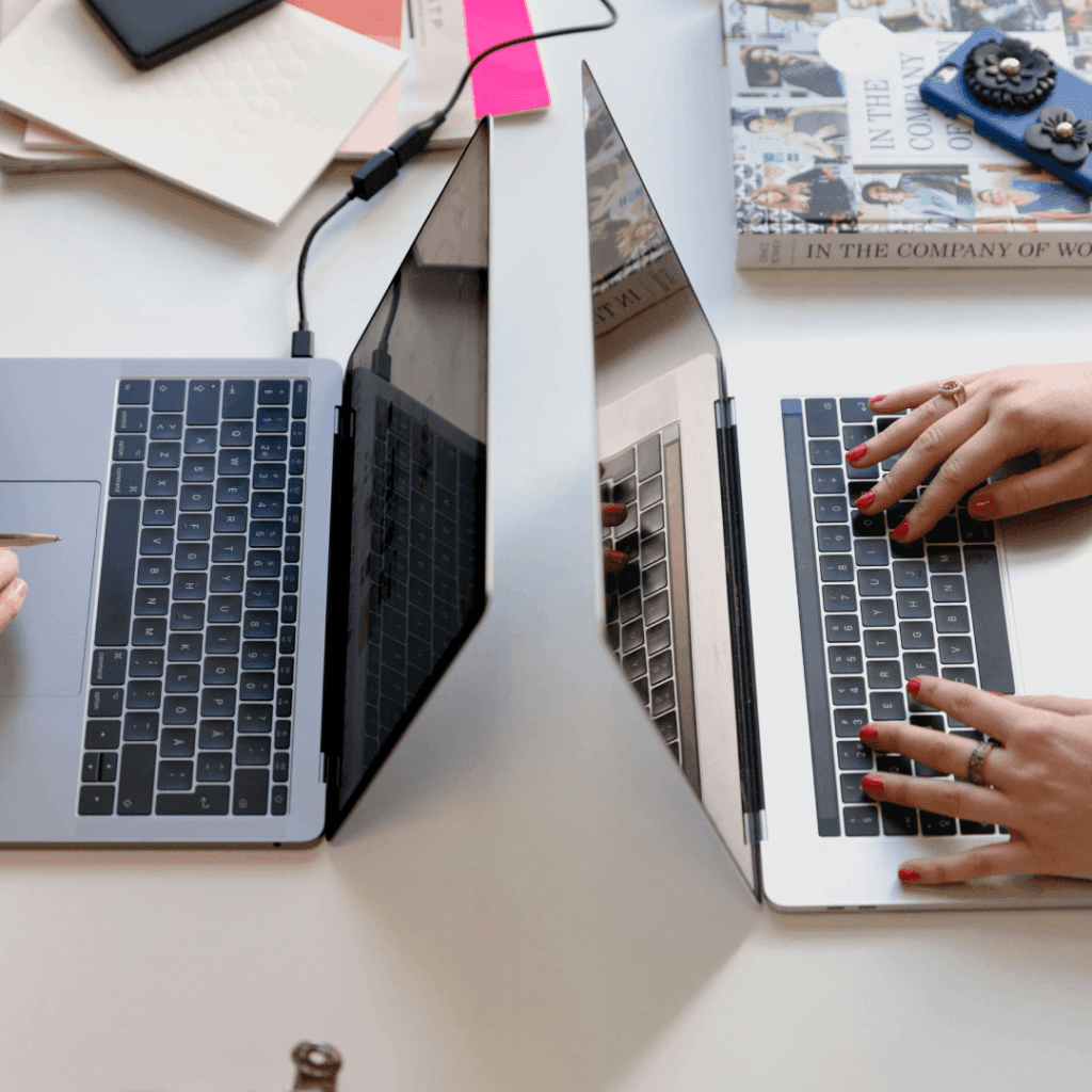 Hands of digital marketing professionals operating laptops, indicative of using the 'Best CRM for Digital Marketing Agency' for efficient client management and strategy execution.