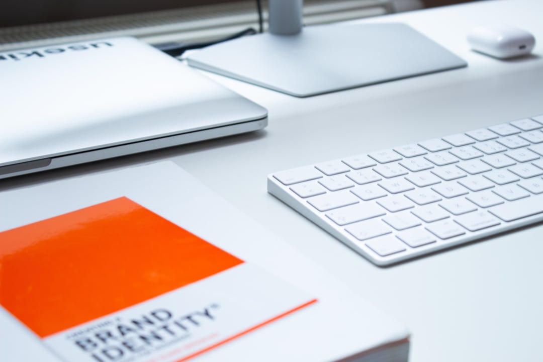 An image of an apple keyboard places next to a book.