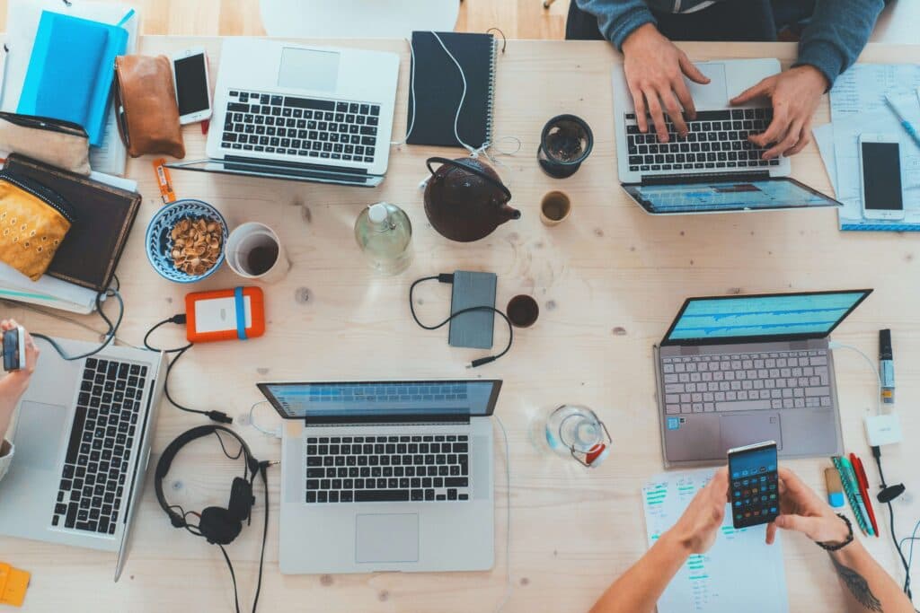 A collaborative workspace with laptops and smartphones, where a marketing team is using AI tools for marketing to analyze data and manage campaigns.