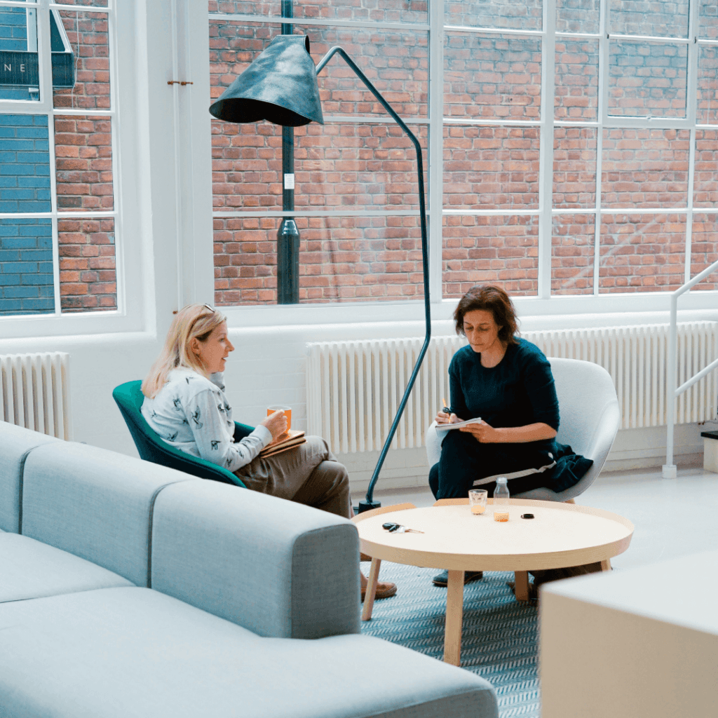 Two marketing professionals discussing the 'Best CRM for Digital Marketing Agency' in a well-lit office space, exemplifying teamwork and strategy development in a modern agency setting