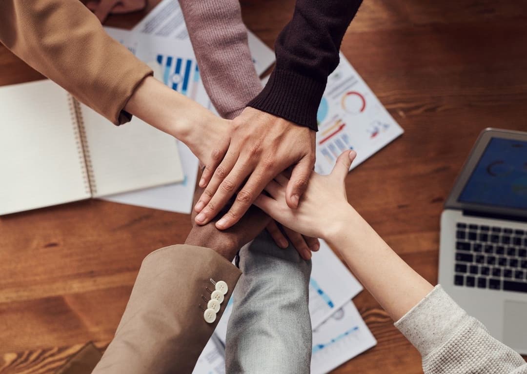 Image of people placing hands on eachothers