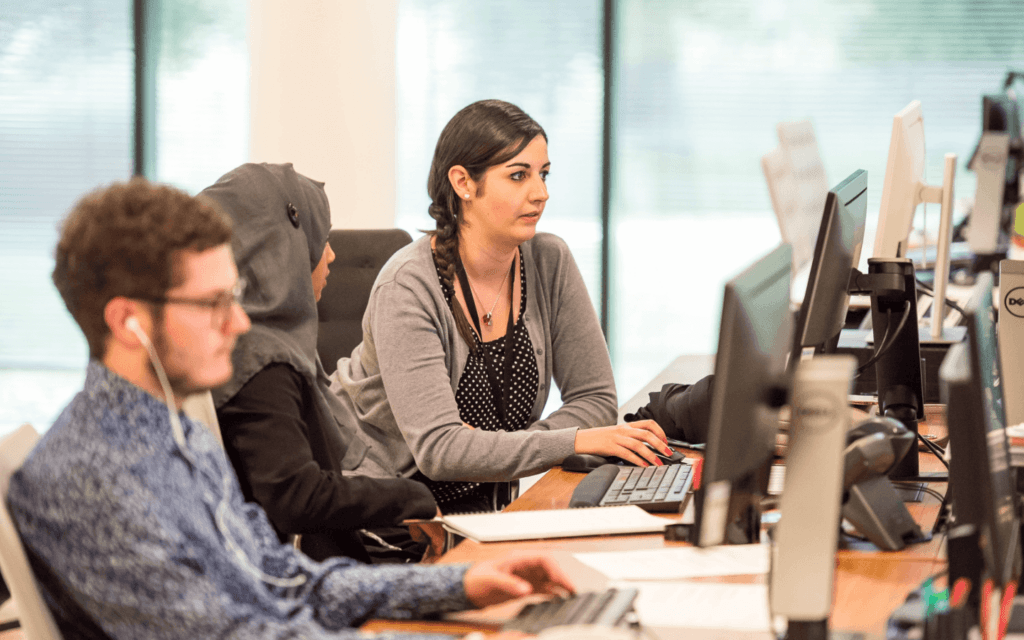 Digital agency professionals concentrated on their work, reflecting the individual focus and teamwork essential for an effective Digital Agency Workflow in an office setting.