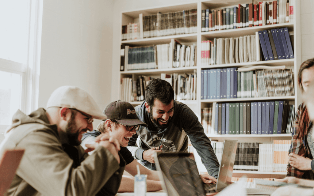 A team of professionals collaborating with enthusiasm in an office, representing a company's commitment to "client retention."