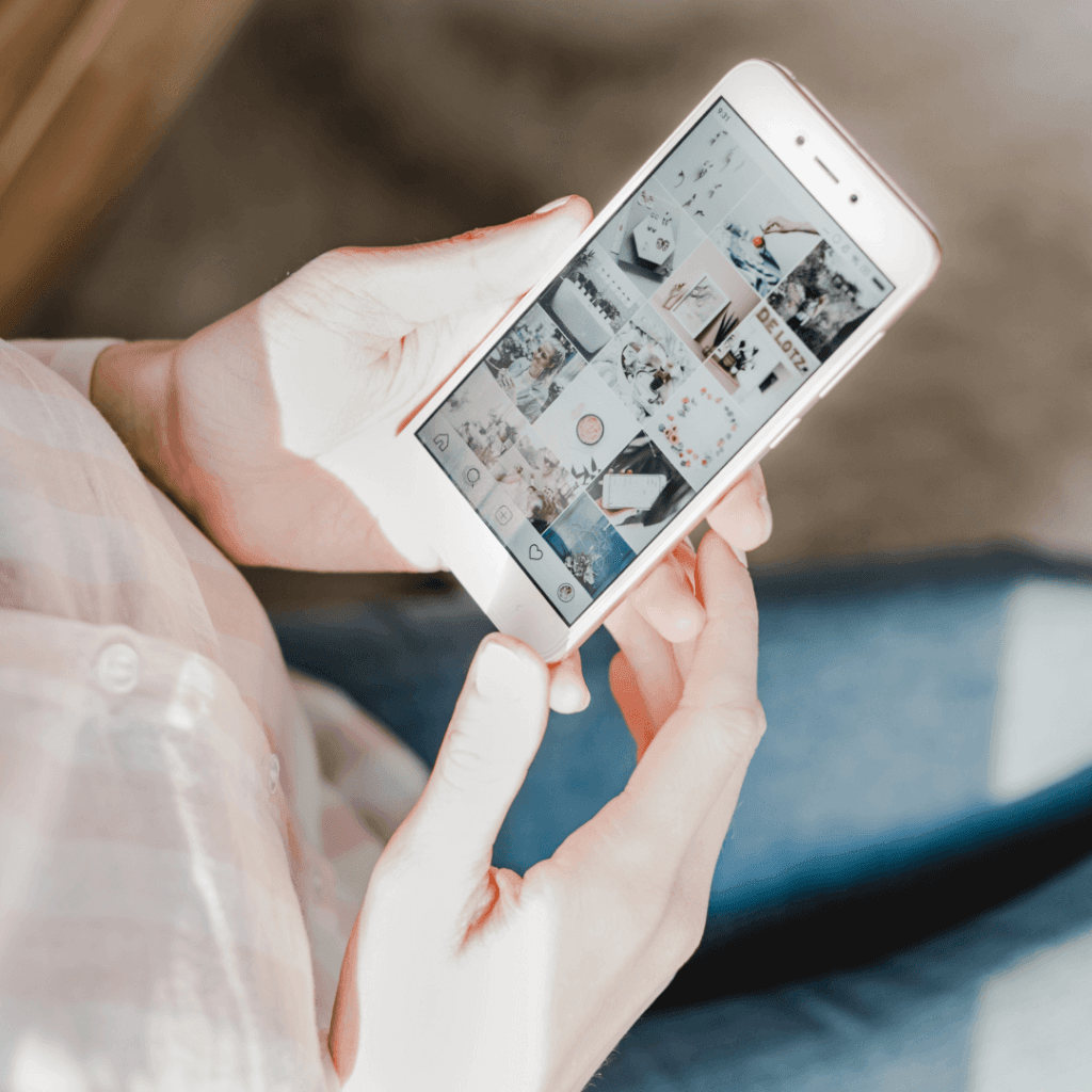 "Person scrolling through an Instagram feed on a smartphone, indicative of user engagement that is measurable through an Instagram Insights Report."