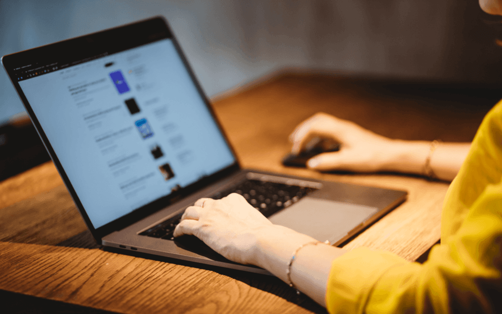 Person analyzing data on a laptop using the best SEO report software, in a cozy workspace with a warm ambiance and wooden desk.