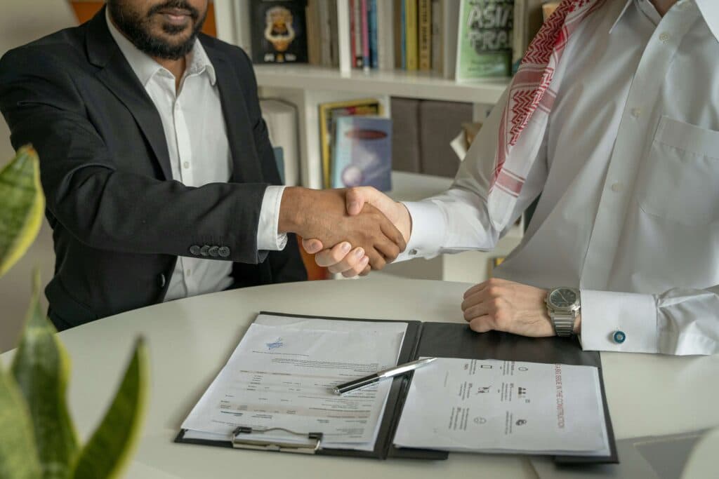 Two professionals shaking hands over a business agreement, highlighting successful collaboration through the use of AI tools for marketing.
