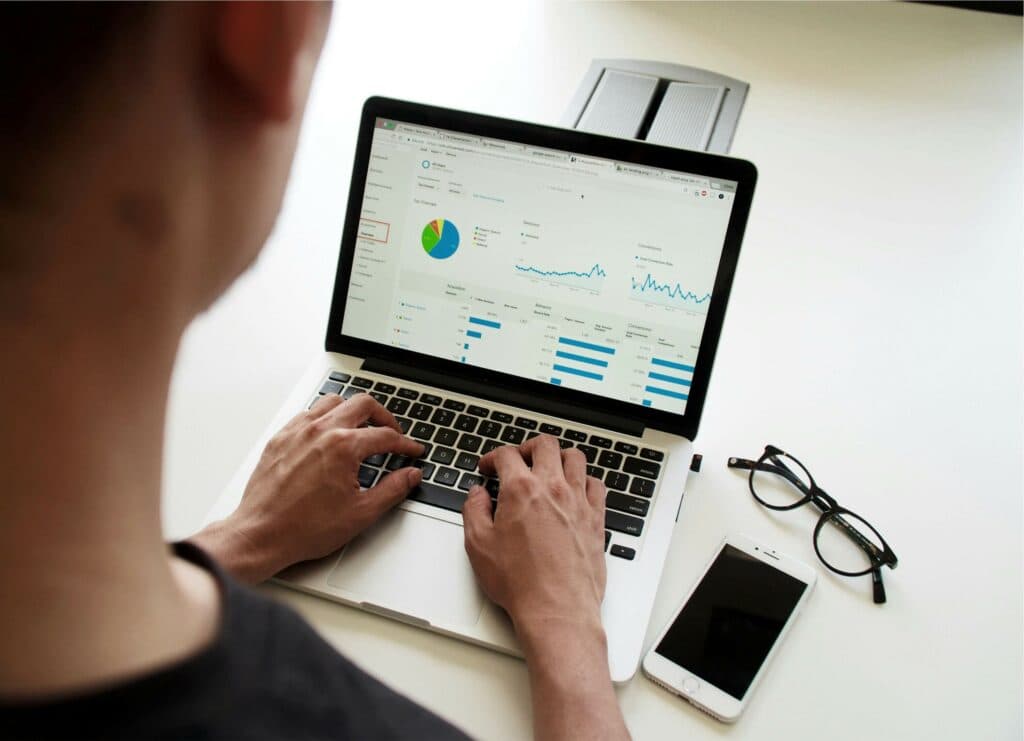 Person analyzing marketing metrics on a laptop screen, representing the use of free AI tools for data-driven decisions in digital marketing agencies.