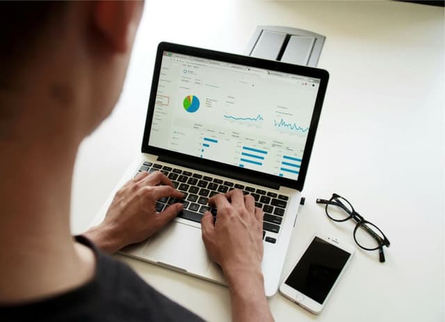 Person analyzing marketing metrics on a laptop screen, representing the use of free AI tools for data-driven decisions in digital marketing agencies.