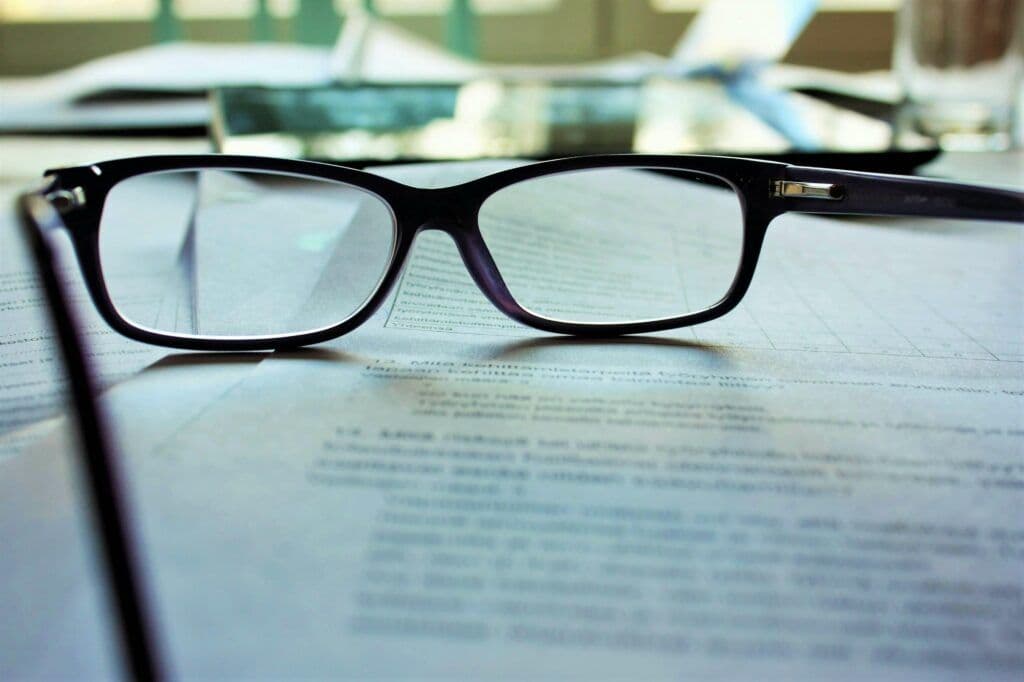 Reading glasses on a document, representing the focus and detailed analysis enabled by free AI tools for digital marketing agencies.