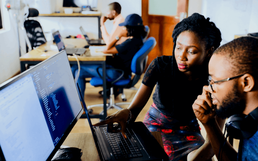Two professionals collaborating on a computer to develop an Ideal Customer Profile in an office environment.