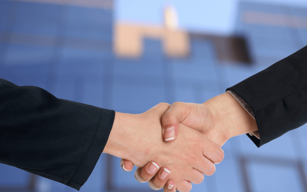 Handshake between two professionals sealing a deal, possibly related to search engine marketing reporting software, with an office backdrop.