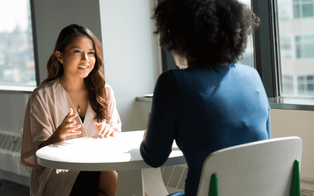 Two professionals in a discussion, potentially exploring the advantages of Search Engine Marketing Reporting Software, in a bright office setting.