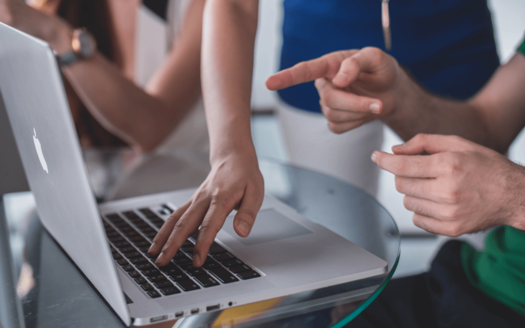 Two professionals collaborating on a laptop, likely utilizing an All in One Digital Marketing Platform to streamline their digital marketing efforts and strategies.