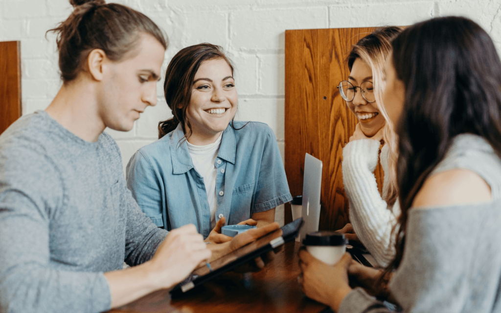 Young digital marketing team working together at a wooden table, exemplifying the collaborative spirit essential for innovative marketing strategy development.