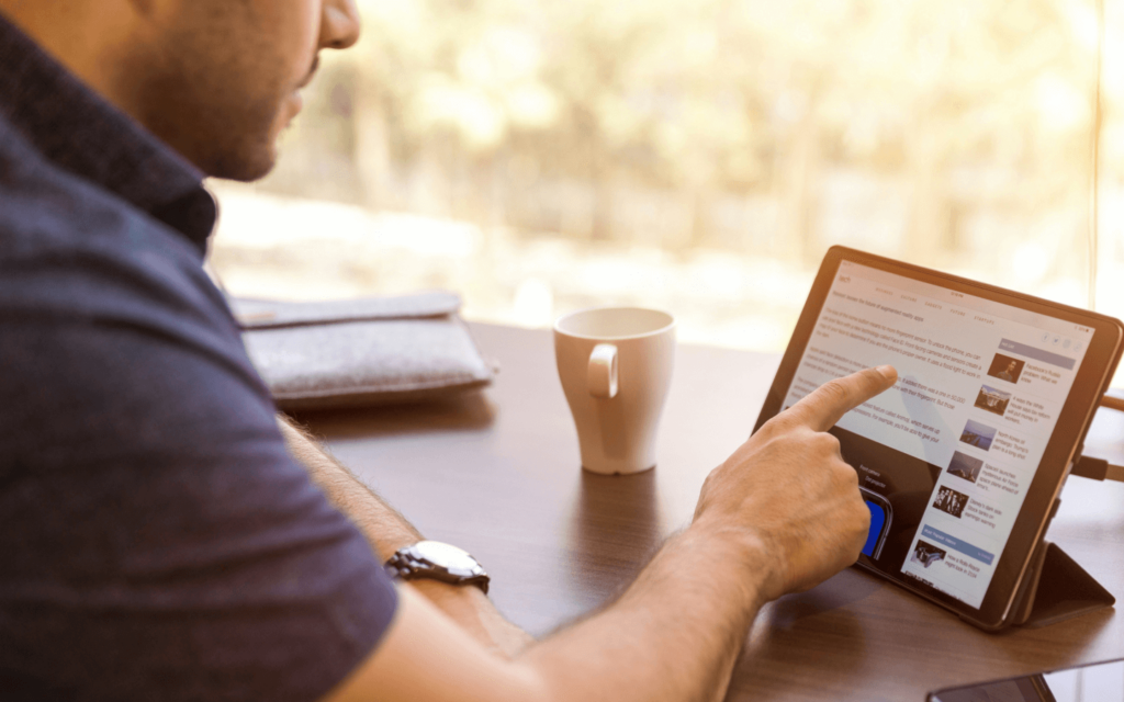 Digital marketing specialist using a stylus to navigate a social media content board on a tablet, highlighting the interactive nature of digital marketing strategy development.