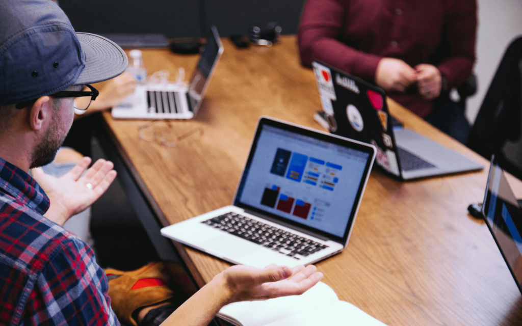 Team members engaged in an influencer marketing strategy meeting, with a focus on data-driven decision making as seen on the laptop screen.