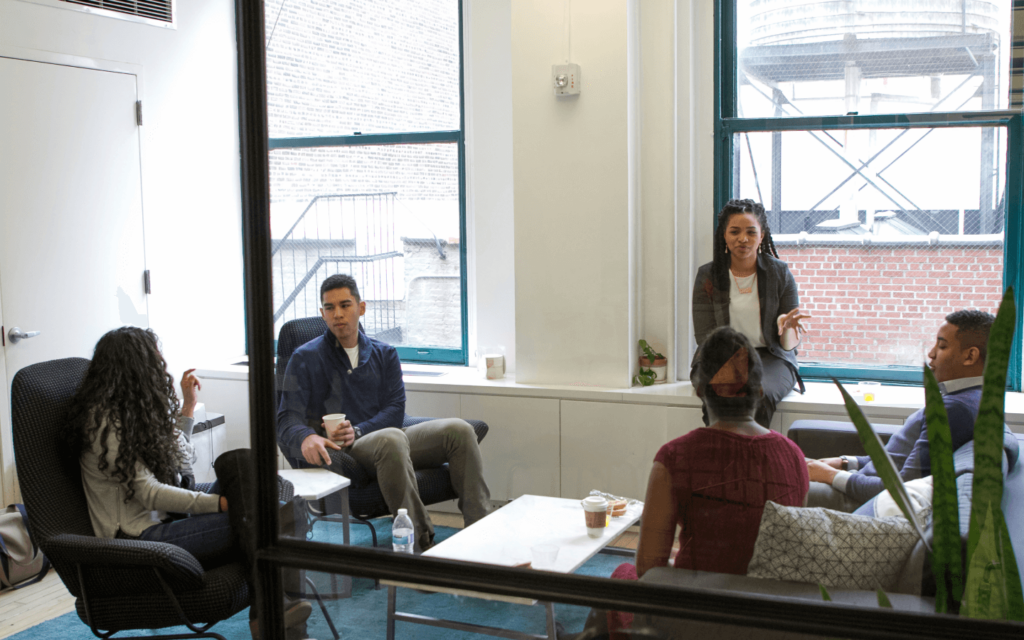 A team of professionals in a collaborative office setting, possibly strategizing on the implementation of a White Label SEO Report Generator for client SEO reports.