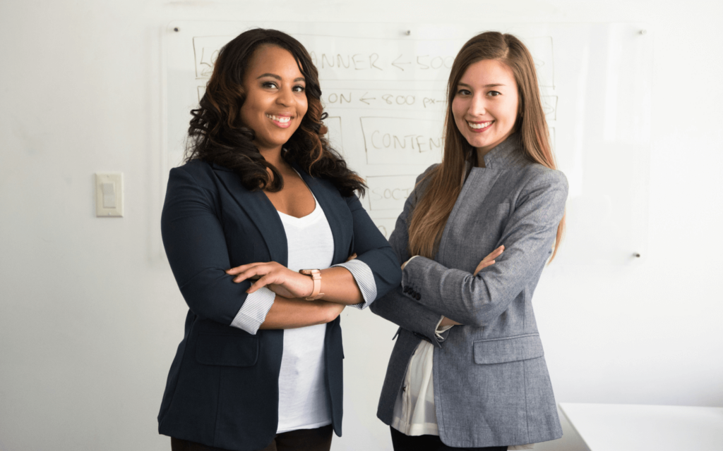 Two professional women, exuding leadership and confidence, possibly strategizing the use of a White Label SEO Report Generator in their marketing initiatives."