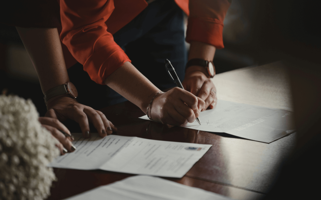 Close-up of a person signing a document, a potential step in formalizing 'Affiliate Marketing for Beginners' partnerships.