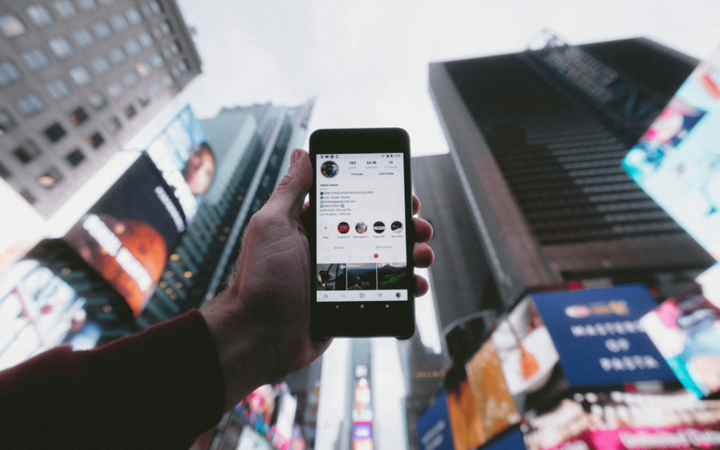 A smartphone screen showing a social media profile held against a city backdrop, symbolizing 'Affiliate Marketing for Beginners' in an urban setting.