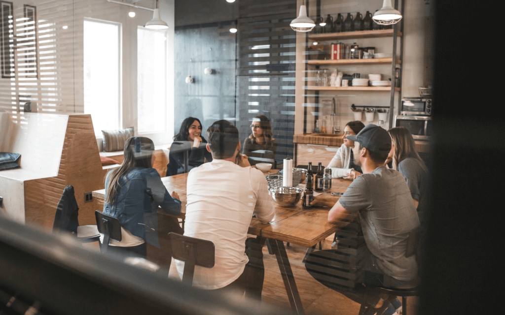 Professionals in a casual office setting engaged in a collaborative discussion about 'White Label Google Analytics Reports', highlighting a blend of teamwork and informal brainstorming.