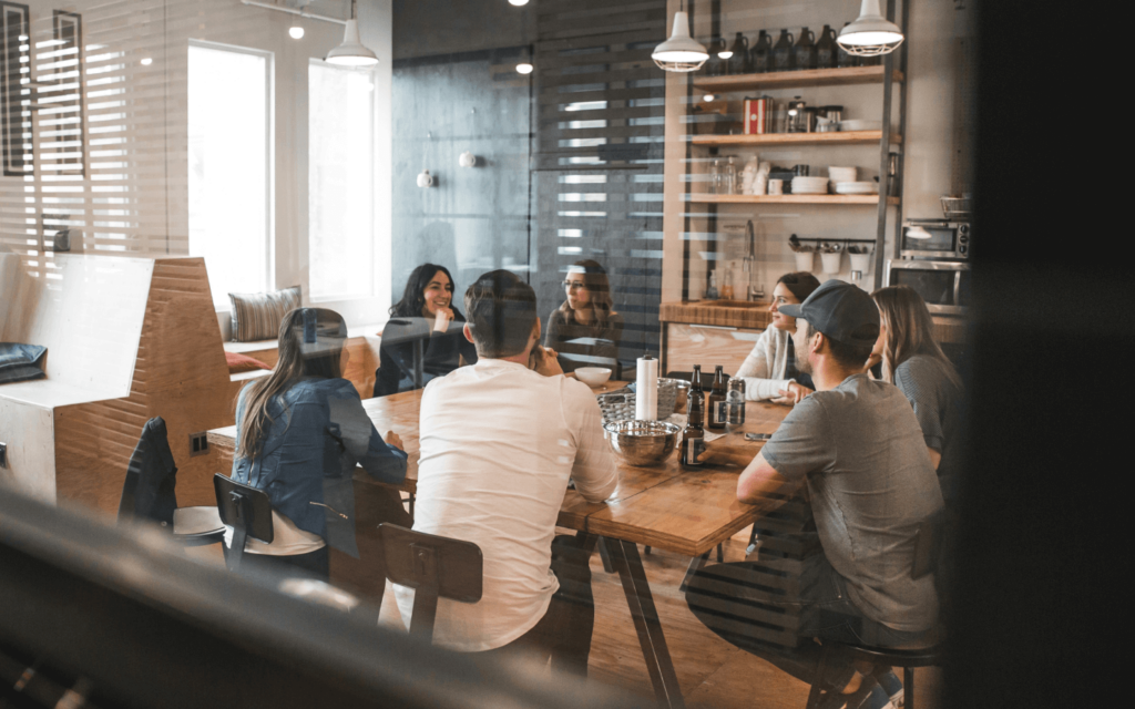 A team gathered in a casual office setting, possibly discussing strategies related to GA 4 reports, encouraging open communication and idea sharing.